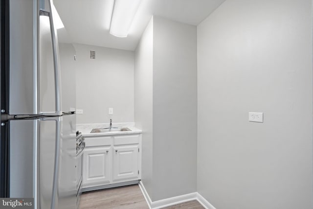 bathroom featuring wood finished floors, vanity, visible vents, and baseboards