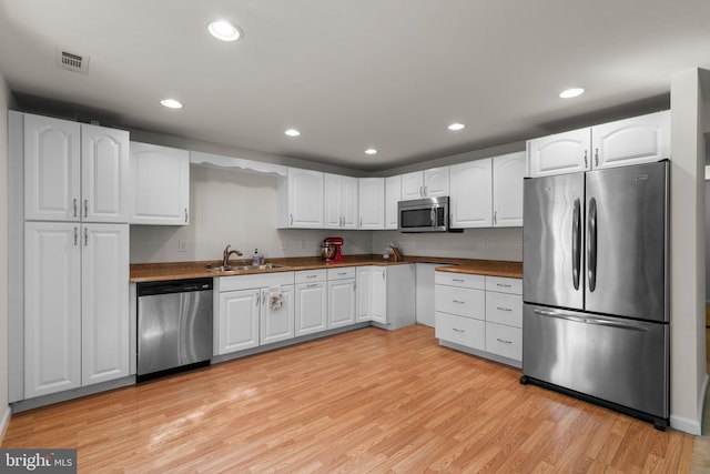 6028 Toomey Ln, Elkridge, MD 21075 - kitchen featuring recessed lighting, white cabinetry, a sink, light wood-style flooring, and appliances with stainless steel finishes