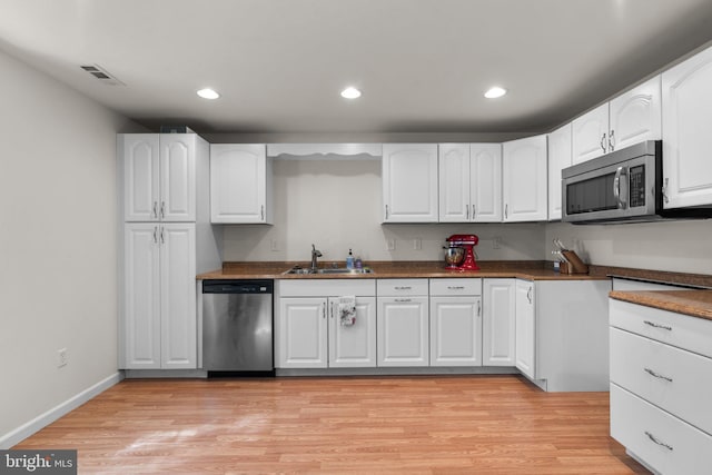 6028 Toomey Ln, Elkridge, MD 21075 - kitchen with light wood-type flooring, a sink, white cabinets, stainless steel appliances, and recessed lighting
