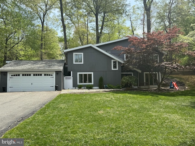 view of front of home featuring a front yard, driveway, and a garage