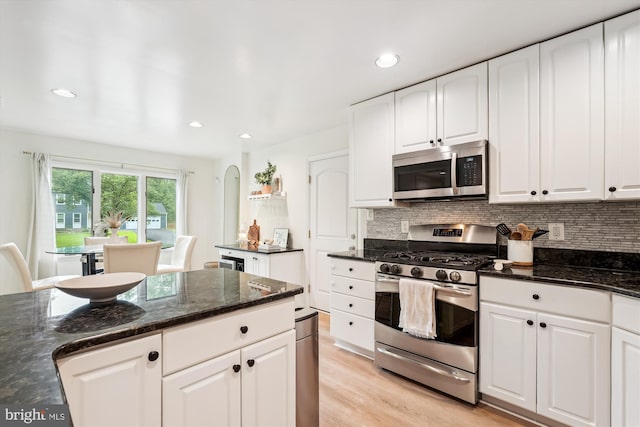 15109 Watergate Rd, Silver Spring, MD 20905 - kitchen featuring appliances with stainless steel finishes, backsplash, dark stone counters, recessed lighting, and white cabinetry