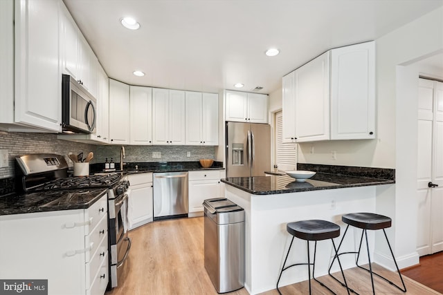 15109 Watergate Rd, Silver Spring, MD 20905 - kitchen with stainless steel appliances, a peninsula, light wood-style floors, a sink, and recessed lighting