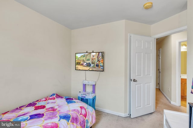 bedroom with baseboards and light colored carpet
