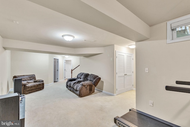 living area featuring light colored carpet, baseboards, and stairway