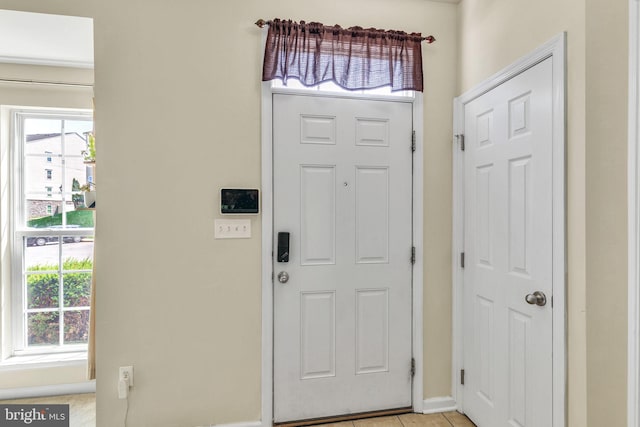 entrance foyer with baseboards, light tile patterned floors, and a wealth of natural light