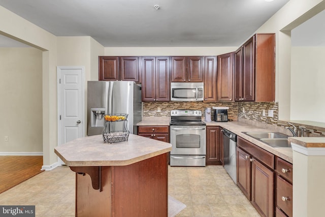 kitchen with light countertops, a sink, decorative backsplash, and stainless steel appliances