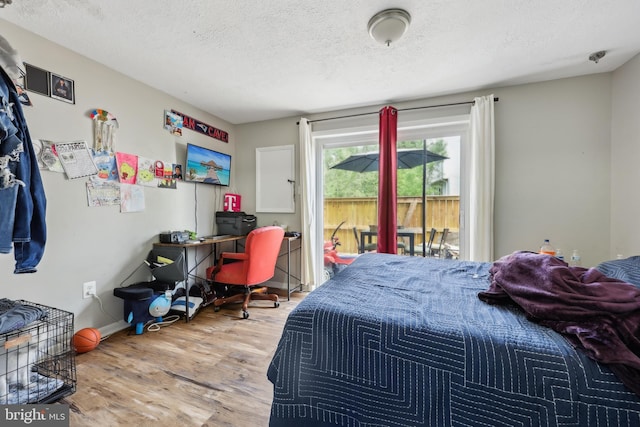 1660 Thenia Pl, Woodbridge, VA 22192 - bedroom with access to outside, baseboards, a textured ceiling, and wood finished floors