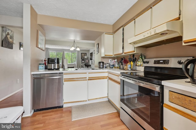 1660 Thenia Pl, Woodbridge, VA 22192 - kitchen featuring a textured ceiling, light countertops, light wood finished floors, under cabinet range hood, and stainless steel appliances