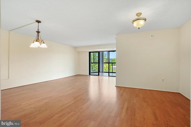 spare room featuring light wood-style floors and baseboards