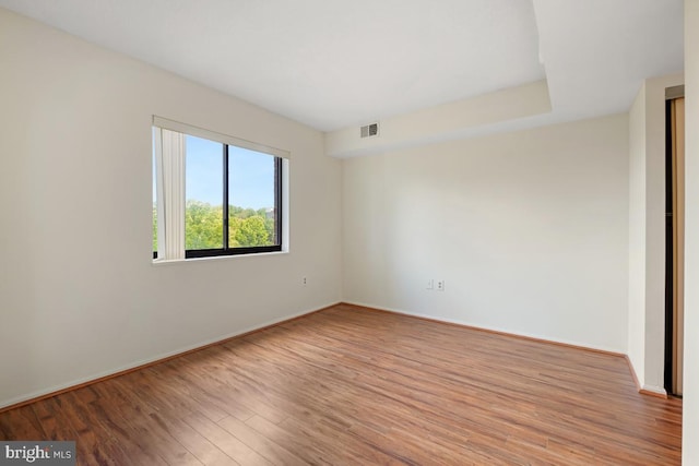 spare room featuring baseboards, visible vents, and light wood-type flooring