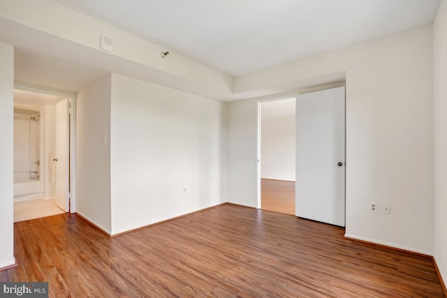 empty room with baseboards and wood finished floors