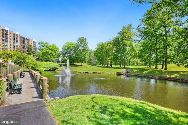 view of community with a yard and a water view