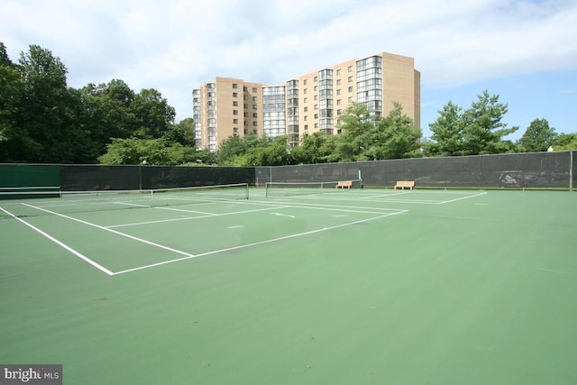 view of tennis court featuring fence and community basketball court
