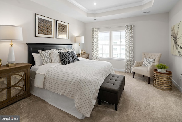 carpeted bedroom with ornamental molding, visible vents, a raised ceiling, and baseboards