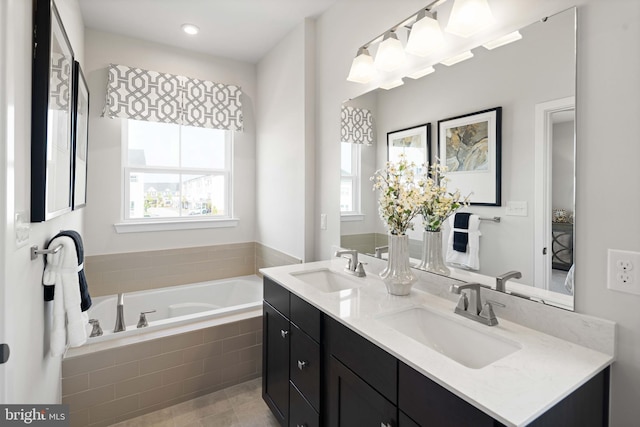 bathroom featuring double vanity, a garden tub, and a sink