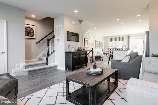 living area with recessed lighting, stairs, light wood-style flooring, and baseboards