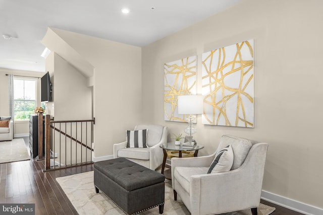 sitting room with baseboards, recessed lighting, an upstairs landing, and wood-type flooring