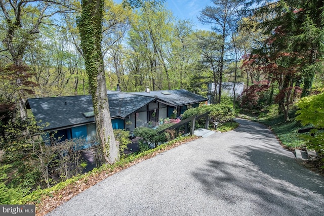 view of home's exterior featuring aphalt driveway and roof with shingles