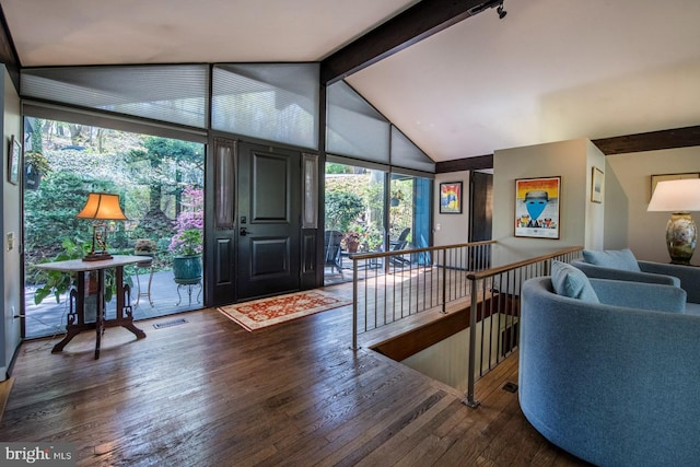 foyer featuring lofted ceiling with beams, wood-type flooring, and visible vents