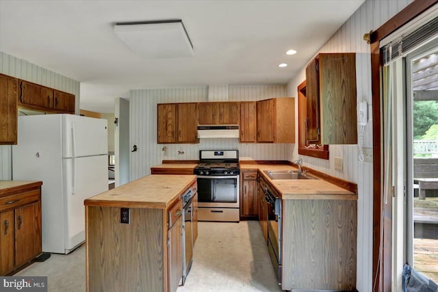 1184 Reservoir Rd, Honey Brook, PA 19344 - kitchen with gas stove, freestanding refrigerator, under cabinet range hood, a center island, and a sink