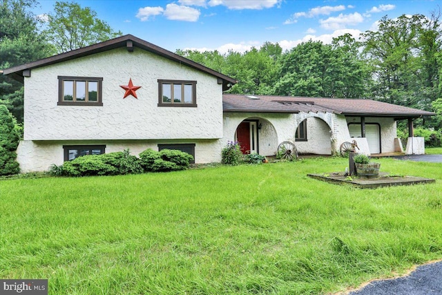 1184 Reservoir Rd, Honey Brook, PA 19344 - split level home featuring an attached garage, a front yard, asphalt driveway, and stucco siding