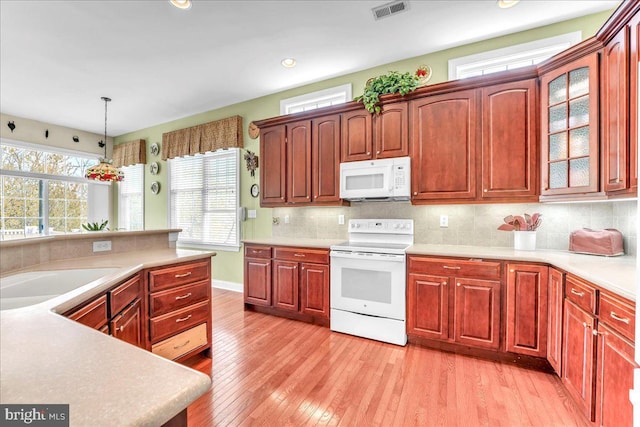 kitchen with visible vents, white appliances, plenty of natural light, and light wood-style flooring