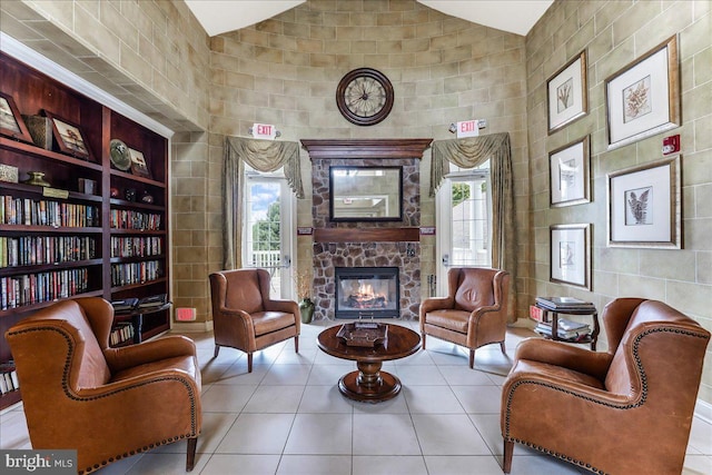 sitting room with tile patterned floors, high vaulted ceiling, and a fireplace