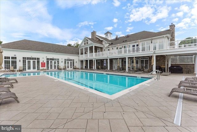 community pool featuring french doors and a patio area
