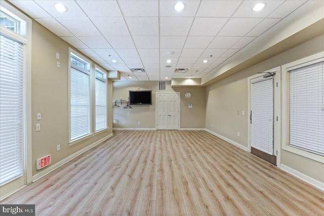 unfurnished living room featuring wood finished floors, a paneled ceiling, visible vents, and baseboards