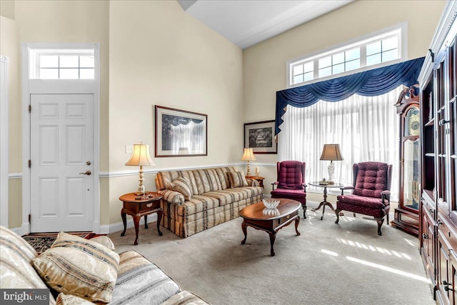 carpeted living area featuring a towering ceiling and a wealth of natural light