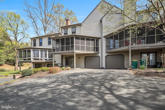 451 Lovell Ct, Hummelstown, PA 17036 - view of front of property featuring driveway, a garage, a chimney, and a sunroom