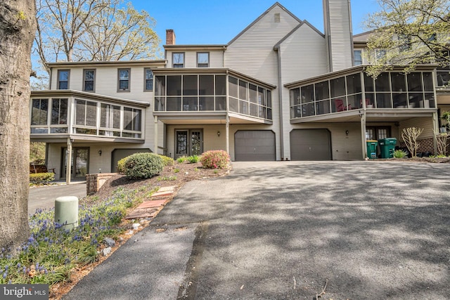 451 Lovell Ct, Hummelstown, PA 17036 - view of front facade featuring driveway, a chimney, an attached garage, and a sunroom