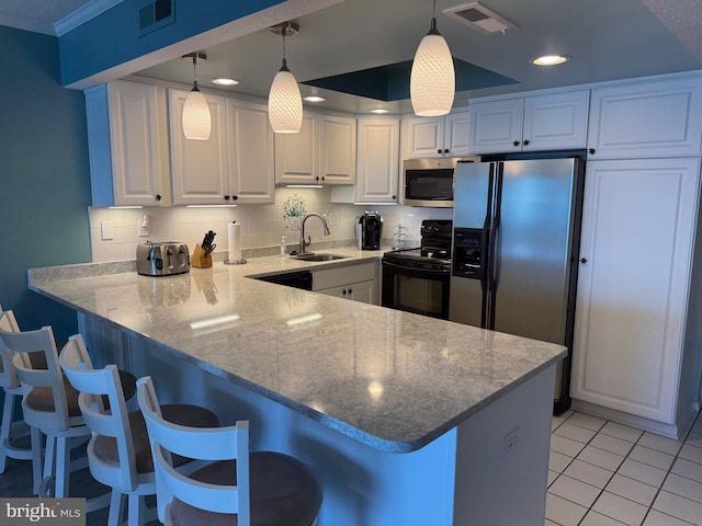 kitchen with a sink, a peninsula, black appliances, visible vents, and white cabinets