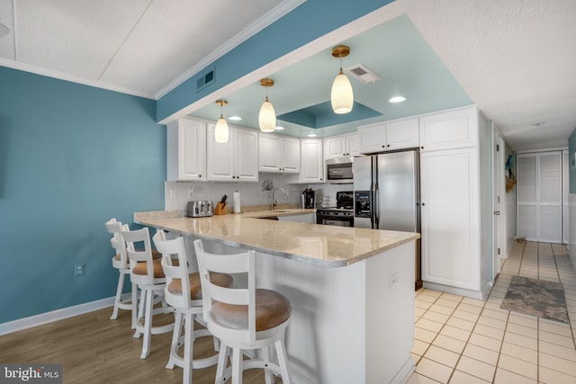 kitchen featuring a peninsula, electric range, visible vents, stainless steel microwave, and fridge with ice dispenser