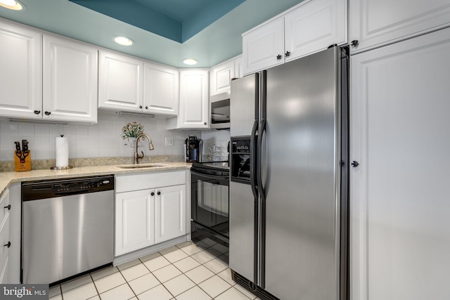 kitchen featuring recessed lighting, light tile patterned flooring, a sink, white cabinets, and appliances with stainless steel finishes