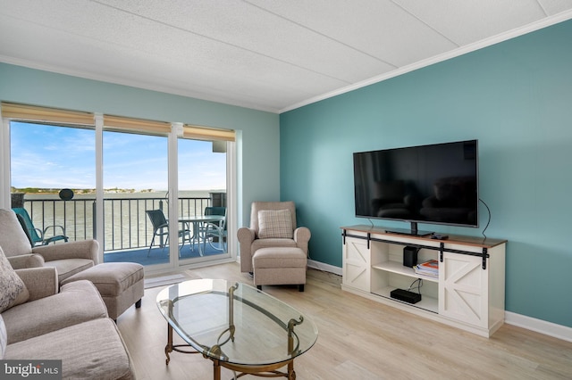 living area with crown molding, baseboards, and wood finished floors