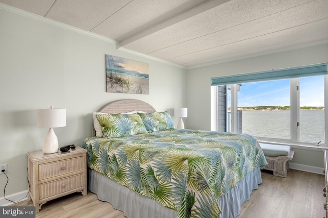 bedroom with crown molding, a water view, baseboards, and light wood-style floors