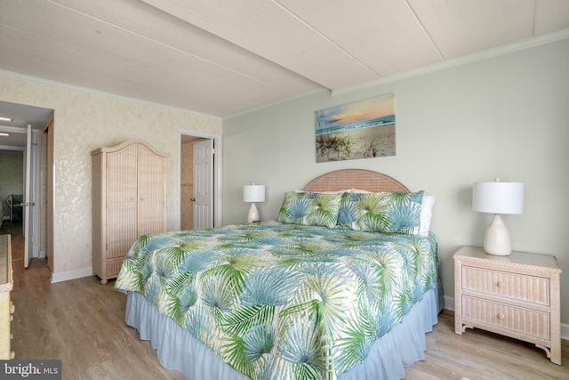 bedroom with baseboards, ornamental molding, wallpapered walls, and wood finished floors