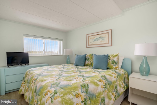 bedroom featuring crown molding and wood finished floors