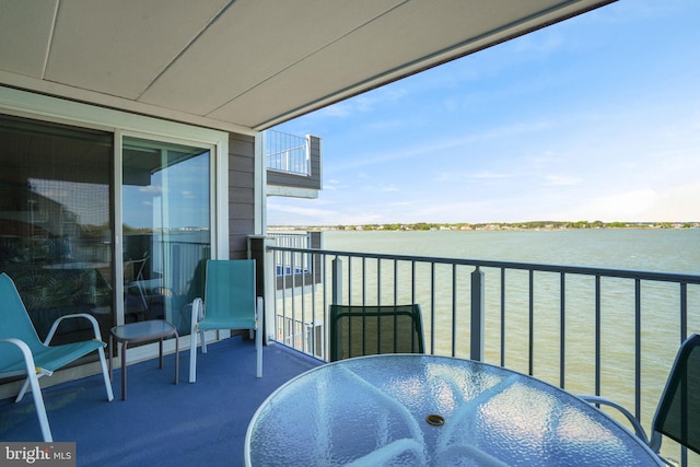 balcony featuring a water view and outdoor dining space