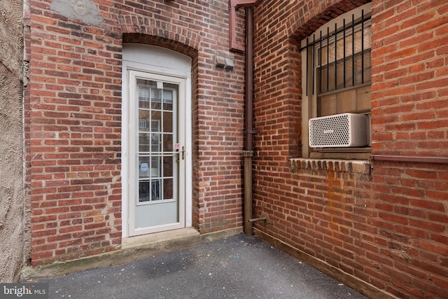 entrance to property with cooling unit and brick siding