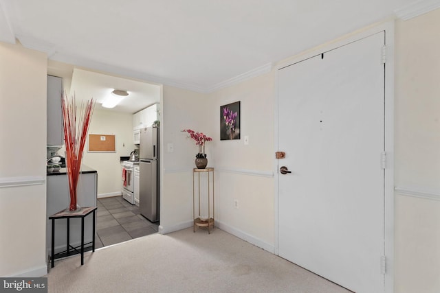 foyer with ornamental molding and baseboards