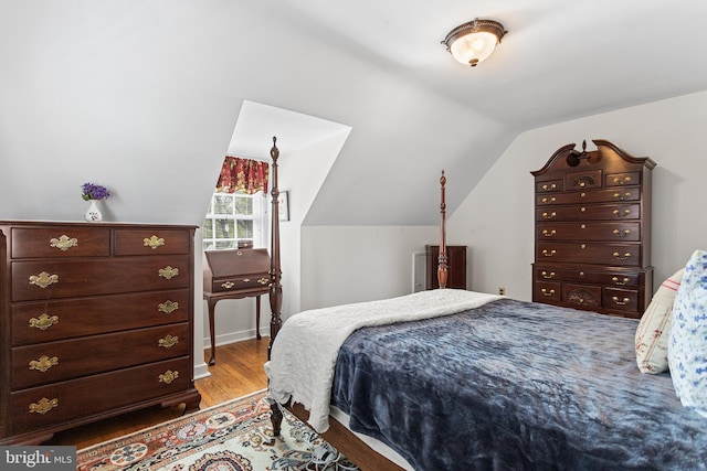 bedroom featuring lofted ceiling and wood finished floors