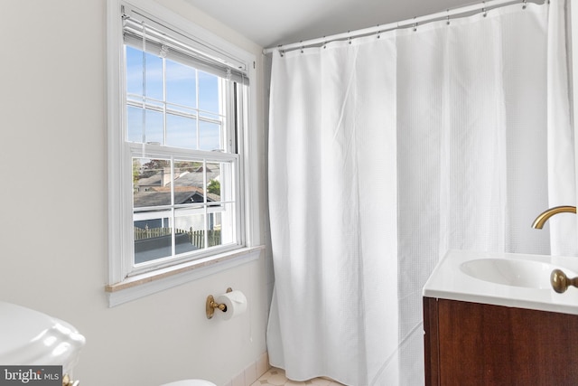 full bathroom featuring toilet, plenty of natural light, and vanity