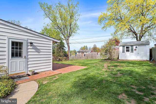 view of yard featuring fence, an outdoor structure, and a shed
