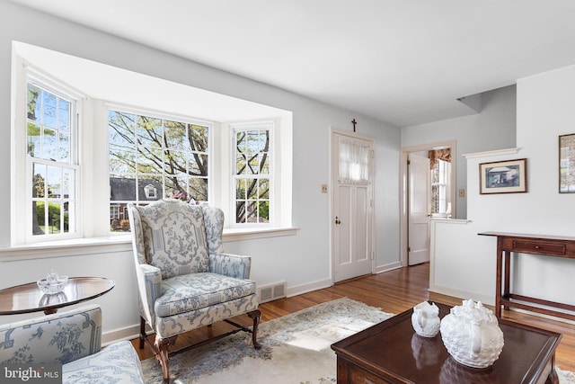 living room with visible vents, baseboards, and wood finished floors