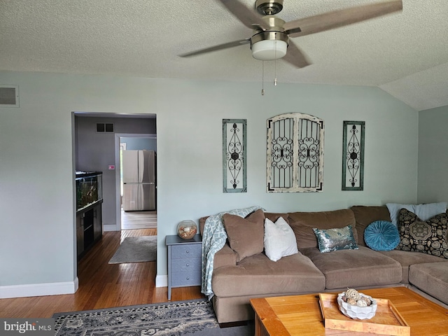 living area featuring baseboards, visible vents, wood finished floors, and ceiling fan