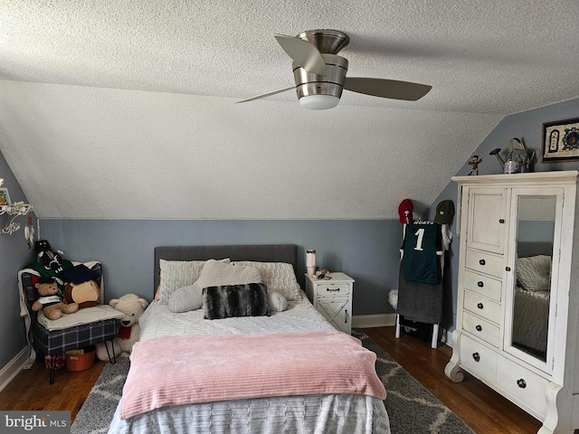 bedroom featuring ceiling fan, dark wood-type flooring, vaulted ceiling, baseboards, and a textured ceiling