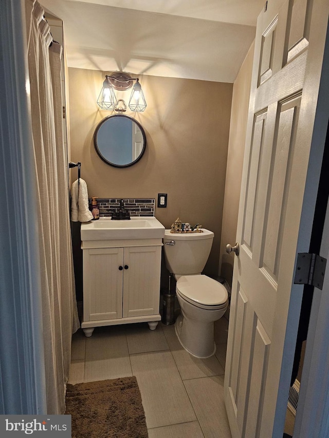 half bathroom featuring tasteful backsplash, toilet, tile patterned flooring, and vanity