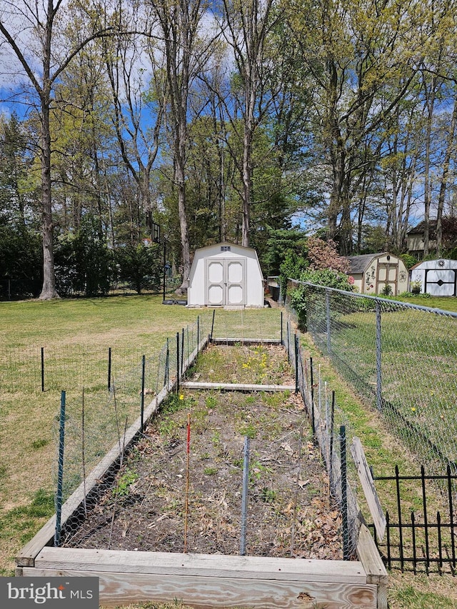 view of yard featuring fence, an outdoor structure, a shed, and a vegetable garden